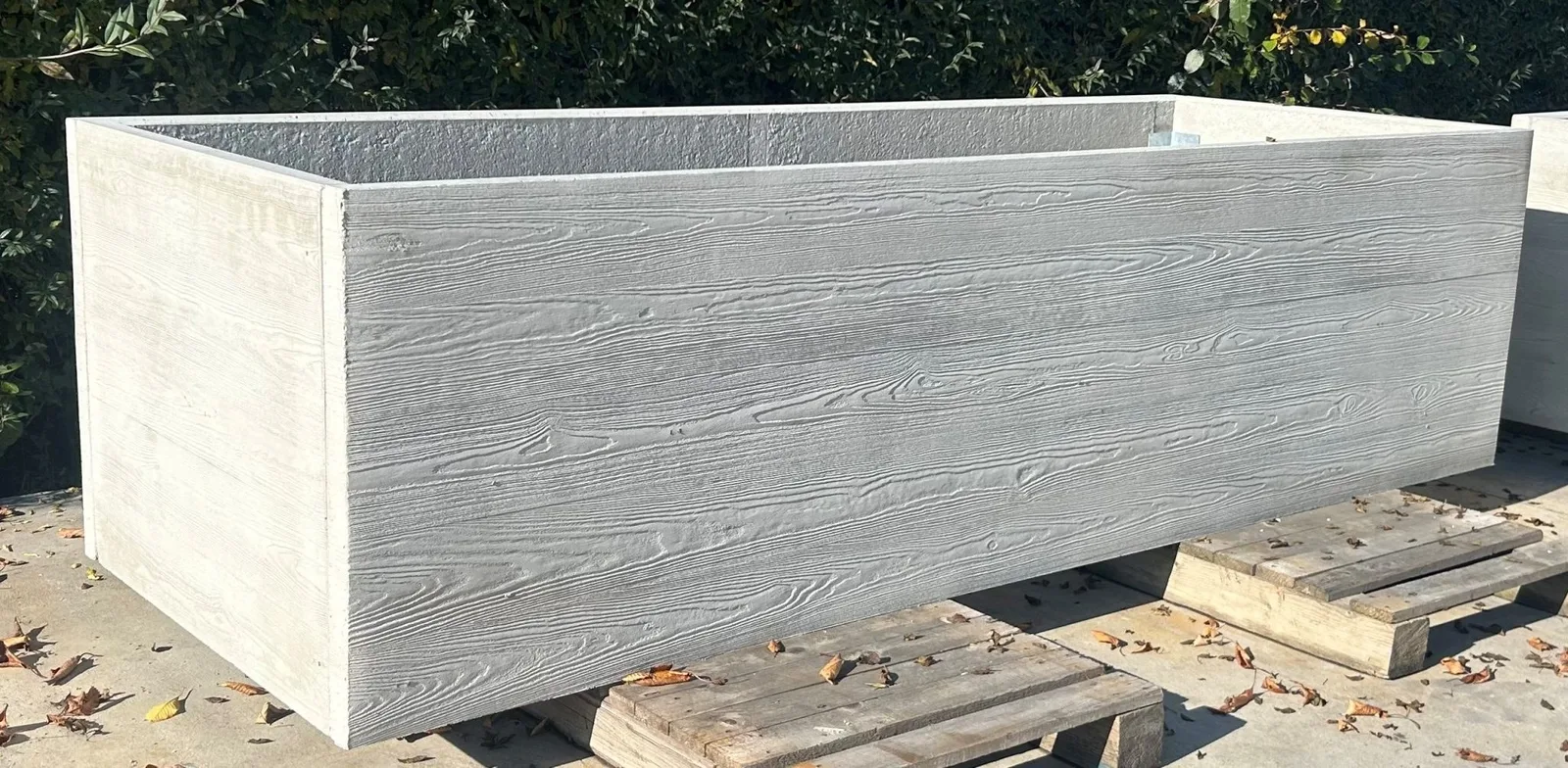 Hochbeet aus Beton in Betongrau mit Holzmaserung auf Paletten