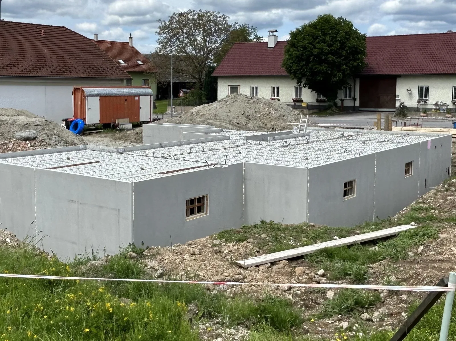Fertiger Keller aus Doppelwänden mit Elementdecke zwischen Bauernhäusern