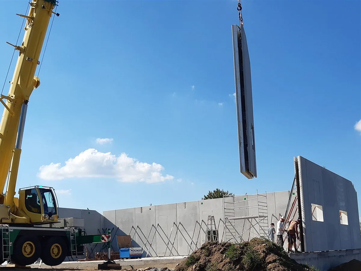 Ein Mobilkran hebt ein hohes Wandelement